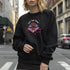 a black sweatshirt featuring a psychedelic "Eat the Rich" design with an eyeball and vampire teeth,